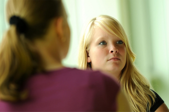 A young girl facing an adult and looking upwards towards something