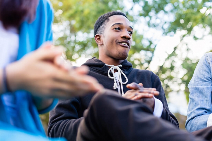 Older boy smiling and clapping in group of people
